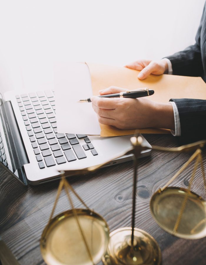 Business and lawyers discussing contract papers with brass scale on desk in office. Law, legal services, advice, justice and law concept picture with film grain effect